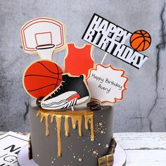 a birthday cake with basketball themed decorations on top and happy birthday stickers above it