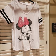 a t - shirt with a minnie mouse on it hanging from a window sill