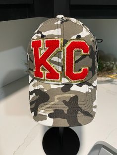 One of a kind Camo hat with KC chenille letters.  Adjustable strap  So one size fits most. colors may vary due to individual monitor settings on your computer or devise. photos are taken in natural light setting. Chiefs Game Day, Leopard Hat, Ku Jayhawks, Chiefs Game, Camo Hat, Purple Hats, Camo Hats, Kc Chiefs, Cute Hats