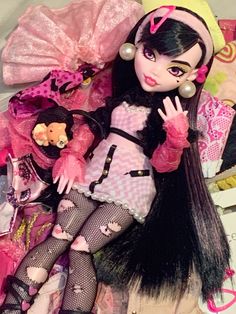 a close up of a doll on a bed with many other dolls in the background