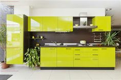 a kitchen with green cabinets and white tile flooring, potted plants on the counter