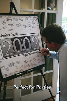 a man is writing on a sign in front of him