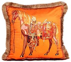 an orange pillow with a horse on the front and fringe trimmings around it