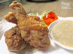 two fried chicken wings on a plate with dipping sauce