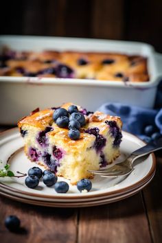 a piece of blueberry cake on a plate with a fork