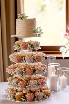 a tiered cake with cupcakes on it