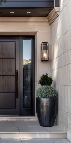 a large black planter sitting in front of a door