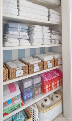 an organized closet with folded towels and baskets