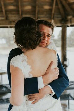 a bride and groom hugging each other in front of a gazebo