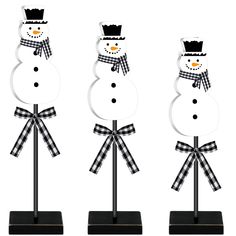 three snowmen with hats and scarfs on their heads