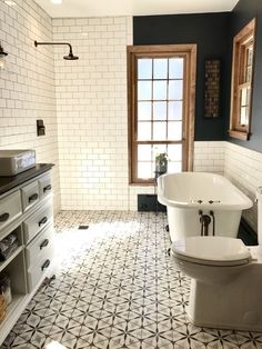 a bathroom with black and white tile flooring and a claw foot tub in the corner