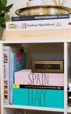 books are stacked on top of each other in a book shelf next to a potted plant