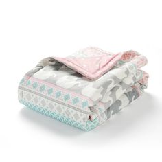 three blankets stacked on top of each other in different colors and patterns, with one blanket folded