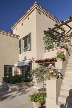 an outside view of a house with stairs and flowers