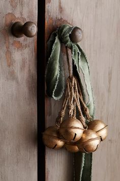 an old door with some metal knobs and green scarf hanging on it's handle