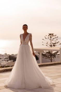 a woman in a wedding dress standing on a balcony