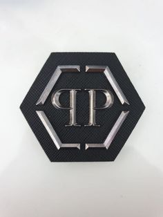 a black and silver emblem with the letter p on it