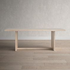 a wooden table sitting on top of a hard wood floor next to a white wall