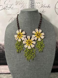 a necklace with yellow and white flowers on it