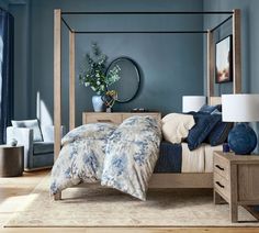 a bedroom with blue walls and furniture in the corner, including a four poster bed