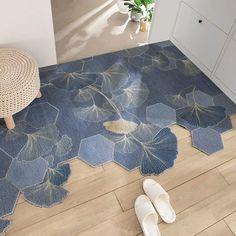 a pair of slippers sitting on top of a wooden floor next to a rug