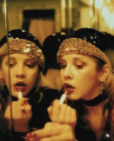 two women are looking at their reflection in the mirror while brushing their teeth with toothbrushes