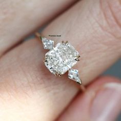 a woman's hand with a diamond ring on top of her finger and an engagement band