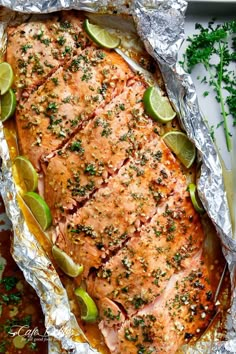 salmon in foil with limes and parsley on top