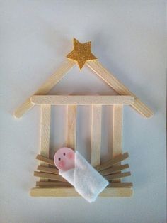 a wooden nativity scene with a star above the baby's crib and clothes pins