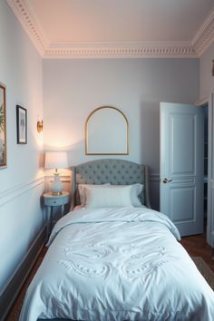 a white bed sitting next to a doorway in a bedroom