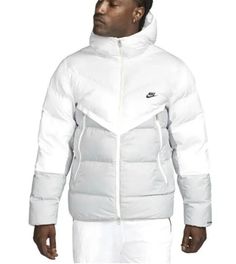 Introducing the Nike Storm-Fit Windrunner Down Puffer Jacket, a perfect addition to your winter/fall wardrobe. Made with softshell polyester material and a cozy hood, this jacket is perfect for casual outdoor activities like walking. The zipper closure and solid pattern add stylish accents to this coat, which comes in a standard fit for men. This white/light smoke grey/black jacket is machine washable and features the Nike logo and product line, storm fit. With its down insulation and polyester lining, this coat will keep you warm without compromising on comfort. Get your hands on this outdoor-themed jacket today! Functional Spring Puffer Jacket For Streetwear, Spring Functional Puffer Jacket For Streetwear, Spring Functional Streetwear Puffer Jacket, White Nylon Urban Puffer Jacket, White Puffer Jacket For Winter Streetwear, Casual Winter White Puffer Jacket For Streetwear, White Hooded Puffer Jacket For Streetwear, White Urban Puffer Outerwear, White Down Puffer Jacket With Long Sleeves