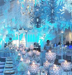 a table is set up with candles and snowflakes in the centerpieces