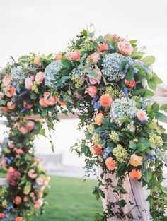 an arch covered in flowers and greenery