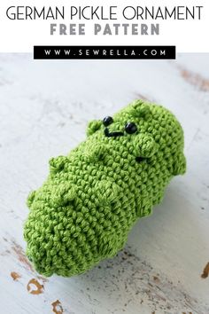 a crocheted green object with black eyes on it and text overlay that reads, german pickle ornament free pattern