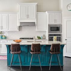 two brown chairs sitting in front of a kitchen island with an oven and microwave on it