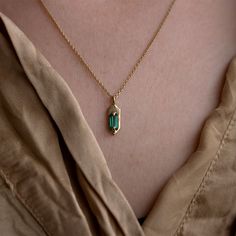 With its modern, understated style, wear this emerald set Amulet necklace for a hint of sparkle and casual luxe. Hanging from the center of the 14K yellow gold chain is a hexagon shaped pendant with two claw prongs that hug a mesmerizing green baguette cut emerald. The best part about this pendent is that it is 100% cu Minimalist Emerald Necklace In Yellow Gold, 14k Gold Emerald Cut Birthstone Necklaces, Emerald Cut Birthstone Necklace In 14k Gold, 14k Gold Emerald Cut Birthstone Necklace, Yellow Gold Necklace With Emerald Rectangular Pendant, Dainty Emerald Cut Yellow Gold Necklace, Minimalist 14k Gold Emerald Gemstone Necklace, 14k Gold Octagon Gemstone Necklace, Gold Emerald Cut Necklace For Everyday Use