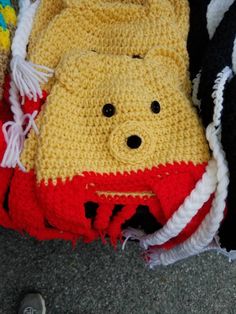 a crocheted winnie the pooh bag is laying on the ground next to other items