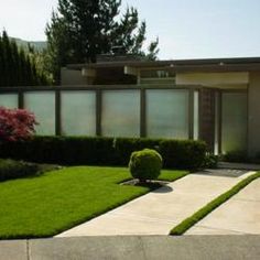 a house with green grass and bushes in front