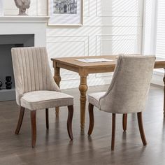 a dining room table with two chairs and a fire place in the corner next to it