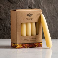 four bees wax candles in a cardboard box