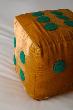 a brown and green square shaped object with polka dots on the top, sitting on a white surface