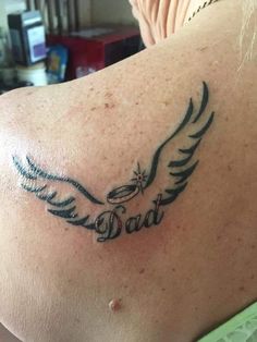 a tattoo on the back of a woman's shoulder that reads, dad and wings