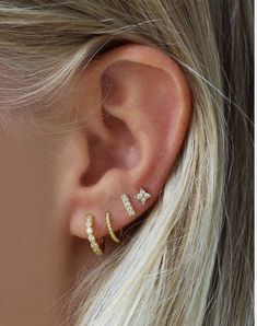 a woman's ear is shown with three different types of piercings