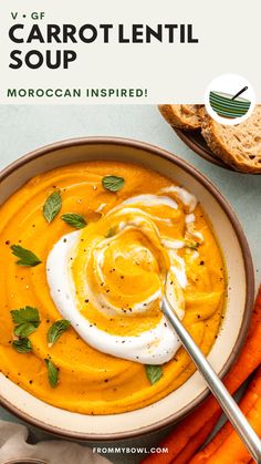 carrot soup in a bowl with sour cream on top and sliced carrots next to it