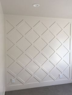 an empty room with white painted walls and carpeted flooring in front of it