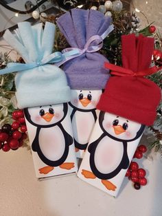 two penguins with hats on their heads are sitting in front of a christmas tree and decorations