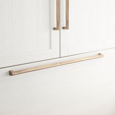 a white cabinet with two wooden handles on it