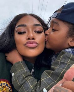 a woman kissing a child on the cheek