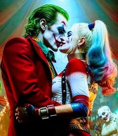 two people dressed as the joker and harley kissing in front of clowns on stage