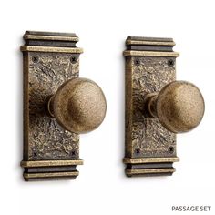 two metal door knobs on the side of a wall